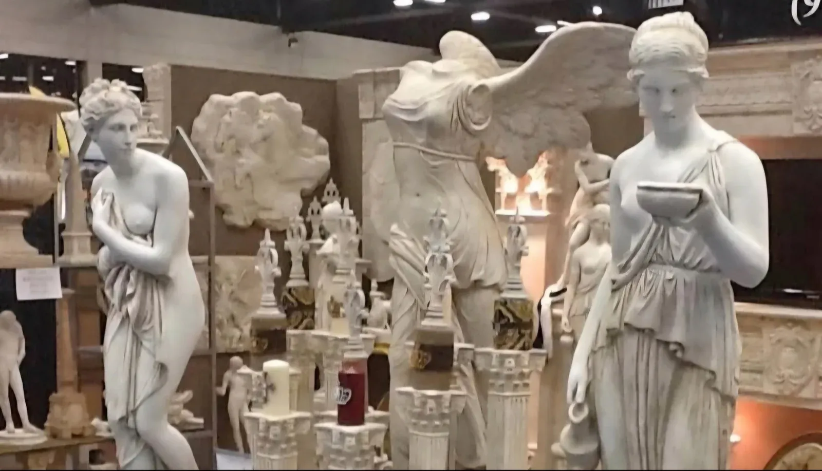 A gallery space lined with classical marble statues and decorative works